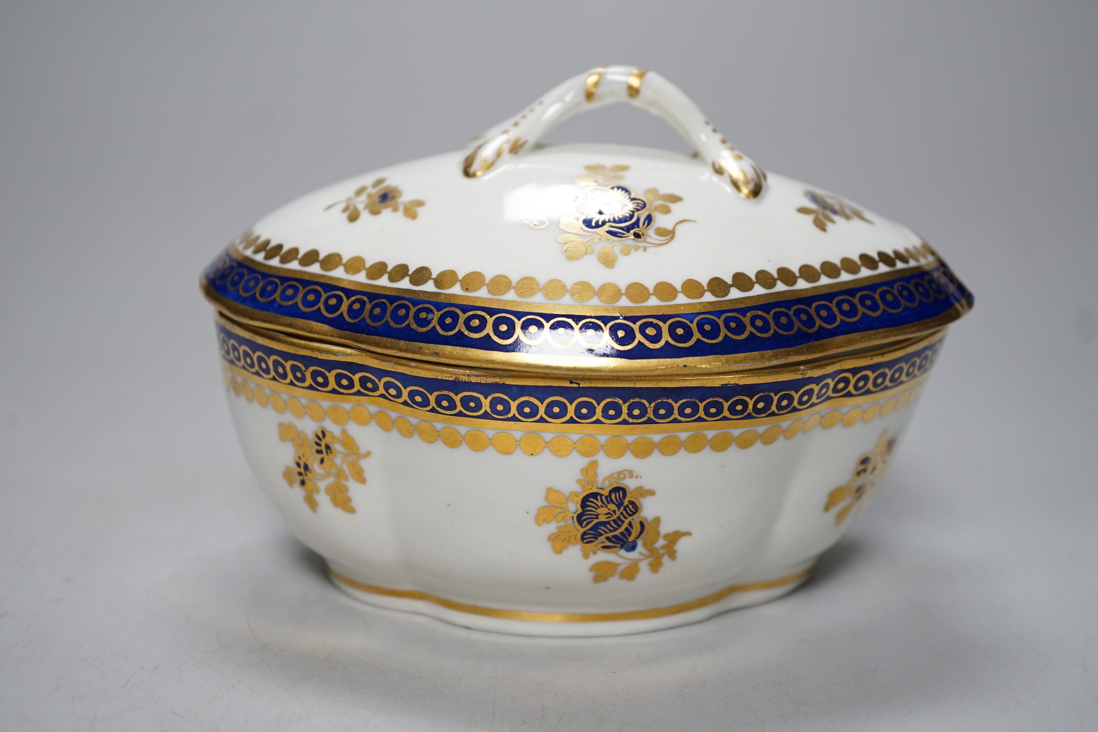 An 18th century Caughley tureen cover and stand with blue and gilt decoration, stand mis-fired to border, S mark to stand and base. 15cm wide